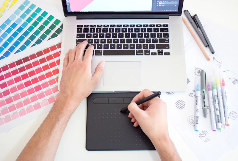 Designer sketching on a pen tablet beside colour swatches